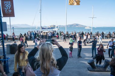 7 Temmuz 2017 - San Francisco, California: Turist kadın alır fotoğraflar Alcatraz Pier 39 iskele, meşgul bir alanı kalabalık turist ile