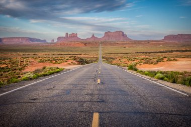 Monument Valley, Arizona ve Utah sınırında dev kırmızı kaya oluşumları yüzölçümü güneş doğarken giden yol