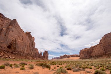 Kırmızı dev kaya oluşumları Vadisi üzerinde bulutlu bir günde Monument Valley, Arizona ve Utah sınırı boyunca artış