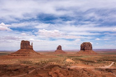 Kırmızı dev kaya oluşumları Vadisi üzerinde bulutlu bir günde Monument Valley, Arizona ve Utah sınırı boyunca dört köşe bölge yükselişi