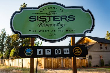 6 Temmuz 2018 - Sisters, Oregon: Hoş geldiniz işareti dusk yaz içinde Sisters Oregon kasaba için.