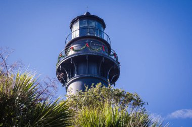 Avcılık Adası feneri Güney Carolina Noel için dekore edilmiş bir mavi gökyüzü karşı