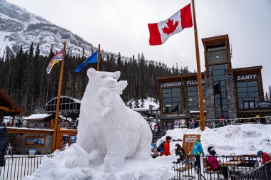 Banff, Alberta Kanada - Janurary 19, 2019: Sunshine köyü kayak alanı Banff kar günlerde lodge önünde bir ayının heykel oyma kar ile. Bir kar fırtınası sırasında alınan