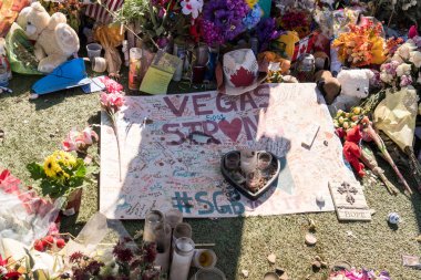 OCT 13 2017 LAS VEGAS NV: Flowers, gifts candles line memorial park at the Welcome to Las Vegas sign by the Mandalay Bay on the Vegas Strip to remember the victims killed in the Las Vegas attack