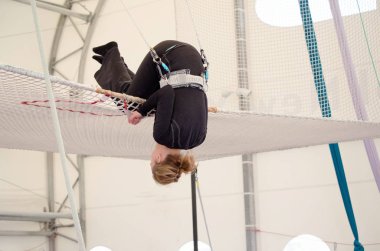 Yetişkin bir kadın, çıkarmak hazırlanıyor bir net, toprakları bir üzerinde uçan bir trapez okulu bir kapalı spor salonu. Amatör bir trapezciye kadındır.