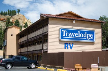 Keystone, SD - June 20, 2018: Exterior of a Travelodge motel building in the summer, offering lodging for travelers clipart