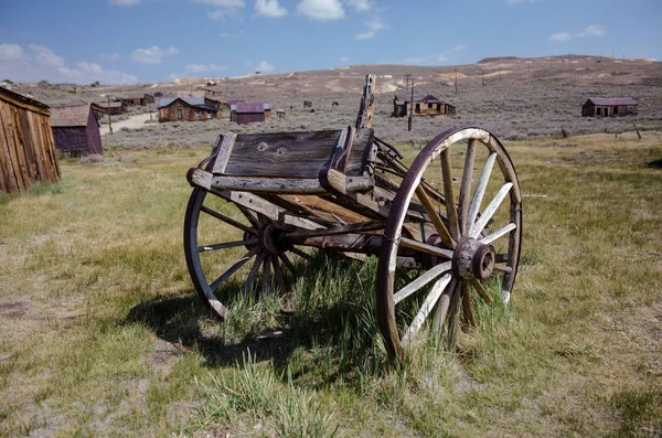 Abandoned mining equipment cart and buildings in the ghost town of Bodie, a California State Historical Park