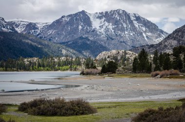 Haziran Gölü içinde California Doğu Sierra Nevada bir bulutlu bahar günü sırasında. Göl su seviyesi düşük ve kurutulmuş kadar nedeniyle-kuraklık için