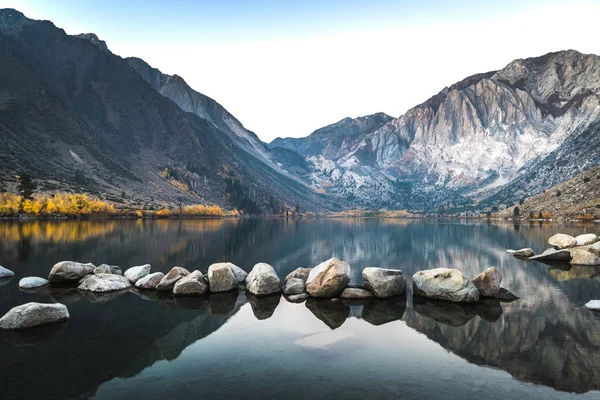 Uzun pozlama gündoğumu fotoğraf mahkum göl, alpenglow bir sonbahar sabahı dağ tepe üzerinde ile California, Sierra nevada dağlarında bir dağ gölü
