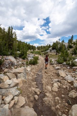 Bir dowhill yamaç küçük Lakes Valley yolun Doğu Sierra Nevada dağlarında yürüyüş sırasında kadın uzun yürüyüşe çıkan kimse konsantreleri