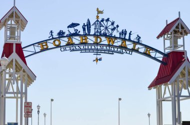 Ocean City, Maryland - April 3, 2018: Arch and welcome sign to the Ocean City Boardwalk on a sunny day. Boardwalk includes restaurants, shops and an amusement park clipart
