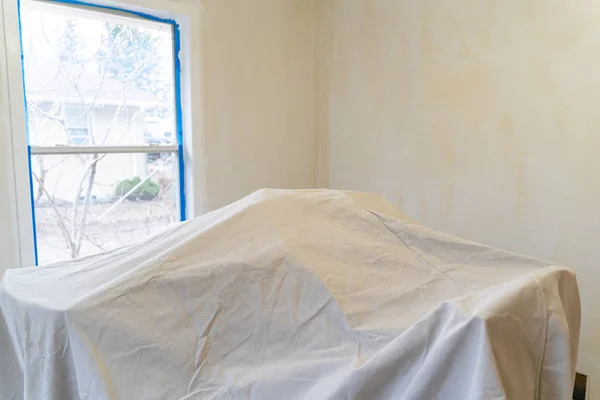 Furniture covered with a painting tarp for protection during hom