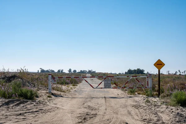 No hay allanamiento y vagabundeo signo y puerta en un camino desierto tierra — Foto de Stock