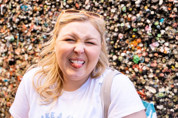 Blonde woman makes a gross face with her tounge out while visiti — Stock Photo, Image