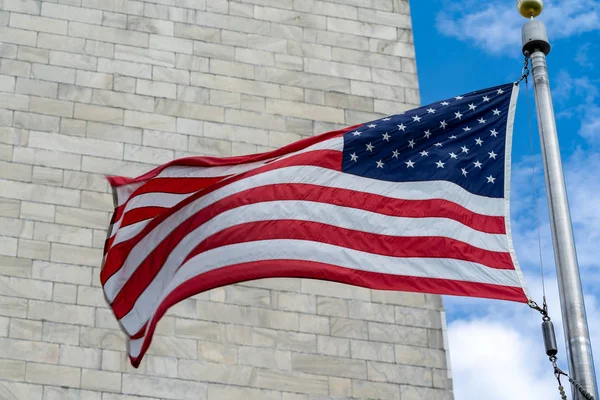 American flag blowing in the wind with the Washington Monument a — Stock Photo, Image