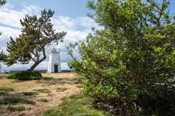 Bush Point Lighthouse, com árvores enquadrando a estrutura náutica — Fotografia de Stock