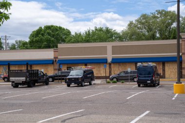 Minneapolis, Minnesota - 29 Mayıs 2020: Çalışma ekipleri, George Floyd 'un polis tarafından öldürülmesinde meydana gelen potansiyel yağma ve ayaklanma hasarını önlemek için kontrplakçı bir alışveriş merkezindeki binalara tahta döşedi