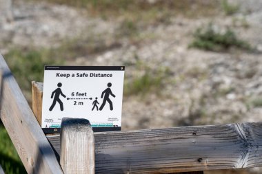 Wyoming, ABD - 2 Temmuz 2020: Yellowstone Ulusal Parkı 'ndaki bir patika başlığını imzalayın, ziyaretçilere COVID-19 salgını sırasında iki metre aralıklı kalmaları gerektiğini hatırlatın.