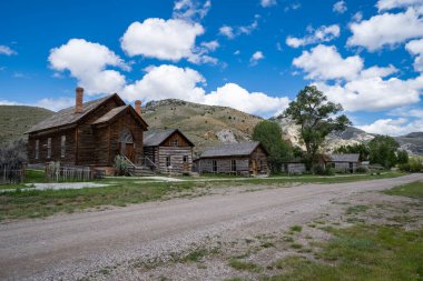 Montana 'daki Bannack Hayalet Kasabası' nda terk edilmiş evler ve binalarla dolu kirli bir yol.