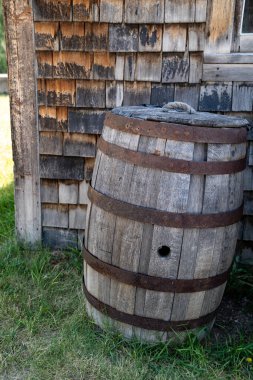 Terk edilmiş bir binanın dışında duran eski moda viski fıçısı. Bannack Hayalet Kasabası Montana 'da çekildi.