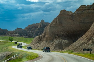 Güney Dakota, ABD - 21 Haziran 2020: Arabalar Badlands Ulusal Parkı 'ndaki Badlands Çevre Yolu' nda bir fırtına gibi ilerliyor