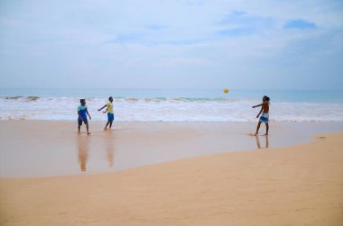Adamlar kumsalda voleybol oynuyorsun.