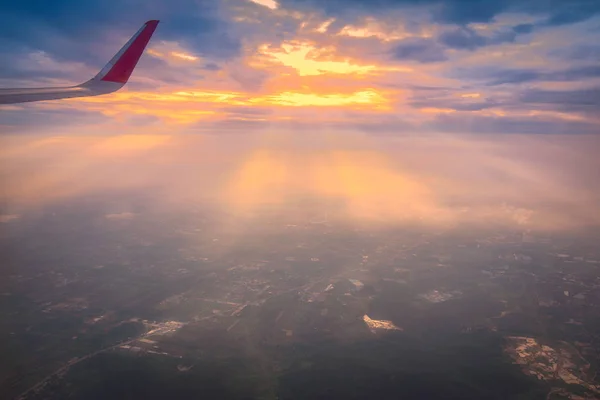 flying plane in air, partial view of airplane wing in sky