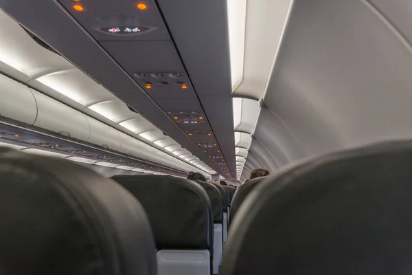 Commercial aircraft cabin with rows of seats down the aisle