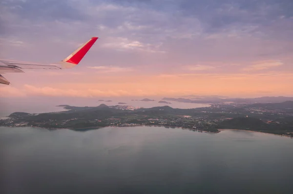 flying plane in air, partial view of airplane wing in sky