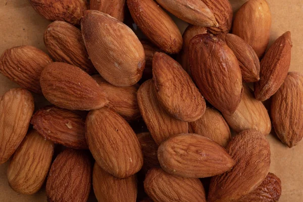 Almonds. Background of big raw peeled almonds situated arbitrarily. Nuts wallpaper pattern. Clipping path. Peeled almonds close up. For vegetarians. Nut pattern.