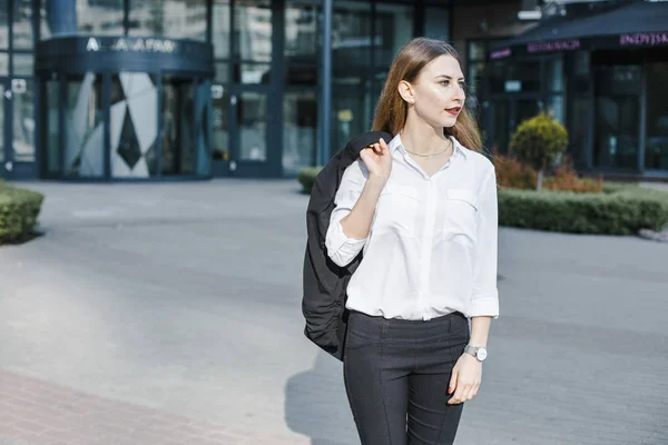 A business woman goes down the street. A girl in a business suit at the office. A wonderful girl in the city.