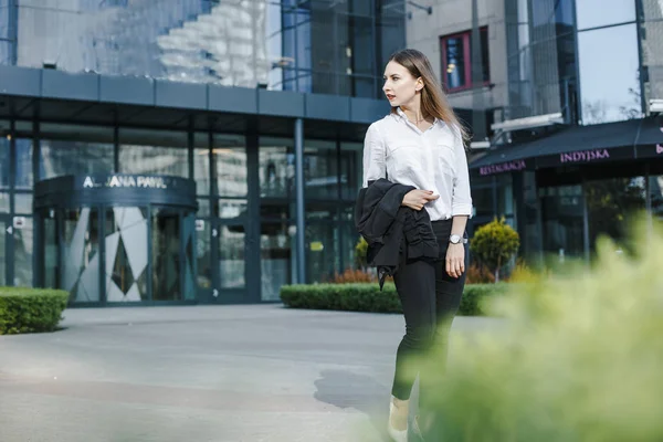 A business woman goes down the street. A girl in a business suit at the office. A wonderful girl in the city.