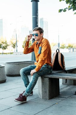 Şık giyinmiş genç adam Varşova sokaklarında. Kent merkezindeki adam. Avrupa şehir seyahat. Evrak çantalı adam. Kırmızı bir vida ile genç bir adam. Genç bir öğrenci eğitim için bir şeyin peşinde. Bir adam işe gider.