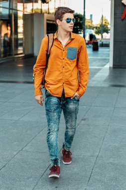 Şık giyinmiş genç adam Varşova sokaklarında. Kent merkezindeki adam. Avrupa şehir seyahat. Evrak çantalı adam. Kırmızı bir vida ile genç bir adam. Genç bir öğrenci eğitim için bir şeyin peşinde. Bir adam işe gider.