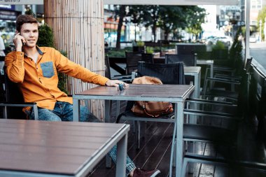 Şık giyinmiş genç adam Varşova sokaklarında. Kent merkezindeki adam. Avrupa şehir seyahat. Evrak çantalı adam. Adam tablo ve çağrıları oturuyor. Adam elini dalgalar ve hoş geldiniz.