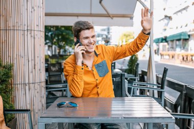 Şık giyinmiş genç adam Varşova sokaklarında. Kent merkezindeki adam. Avrupa şehir seyahat. Evrak çantalı adam. Adam tablo ve çağrıları oturuyor. Adam elini dalgalar ve hoş geldiniz.