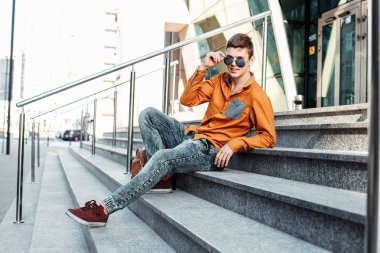 Şık giyinmiş genç adam Varşova sokaklarında. Kent merkezindeki adam. Avrupa şehir seyahat. Evrak çantalı adam. Kırmızı bir vida ile genç bir adam. Genç bir öğrenci eğitim için bir şeyin peşinde. Bir adam işe gider.