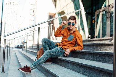 Şık giyinmiş genç adam Varşova sokaklarında. Kent merkezindeki adam. Avrupa şehir seyahat. Evrak çantalı adam. Kırmızı bir vida ile genç bir adam. Genç bir öğrenci eğitim için bir şeyin peşinde. Bir adam işe gider.