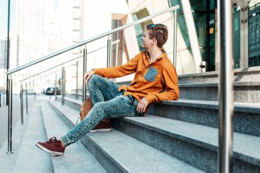 Şık giyinmiş genç adam Varşova sokaklarında. Kent merkezindeki adam. Avrupa şehir seyahat. Evrak çantalı adam. Kırmızı bir vida ile genç bir adam. Genç bir öğrenci eğitim için bir şeyin peşinde. Bir adam işe gider.