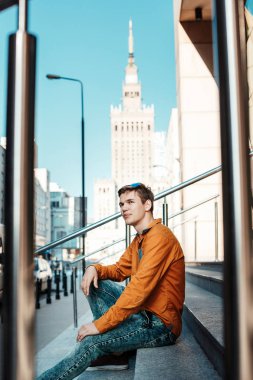 Şık giyinmiş genç adam Varşova sokaklarında. Kent merkezindeki adam. Avrupa şehir seyahat. Evrak çantalı adam. Kırmızı bir vida ile genç bir adam. Genç bir öğrenci eğitim için bir şeyin peşinde. Bir adam işe gider.