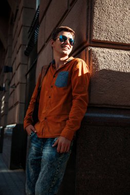 Şık giyinmiş genç adam Varşova sokaklarında. Kent merkezindeki adam. Avrupa şehir seyahat. Evrak çantalı adam. Kırmızı bir vida ile genç bir adam. Genç bir öğrenci eğitim için bir şeyin peşinde. Bir adam işe gider.