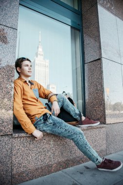 Şık giyinmiş genç adam Varşova sokaklarında. Kent merkezindeki adam. Avrupa şehir seyahat. Evrak çantalı adam. Kırmızı bir vida ile genç bir adam. Genç bir öğrenci eğitim için bir şeyin peşinde. Bir adam işe gider.