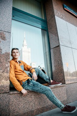 Şık giyinmiş genç adam Varşova sokaklarında. Kent merkezindeki adam. Avrupa şehir seyahat. Evrak çantalı adam. Kırmızı bir vida ile genç bir adam. Genç bir öğrenci eğitim için bir şeyin peşinde. Bir adam işe gider.