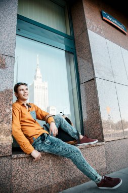 Şık giyinmiş genç adam Varşova sokaklarında. Kent merkezindeki adam. Avrupa şehir seyahat. Evrak çantalı adam. Kırmızı bir vida ile genç bir adam. Genç bir öğrenci eğitim için bir şeyin peşinde. Bir adam işe gider.