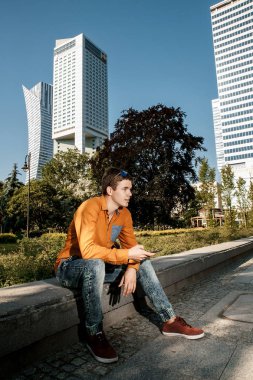 Şık giyinmiş genç adam Varşova sokaklarında. Kent merkezindeki adam. Avrupa şehir seyahat. Evrak çantalı adam. Kırmızı bir vida ile genç bir adam. Genç bir öğrenci eğitim için bir şeyin peşinde. Bir adam işe gider.