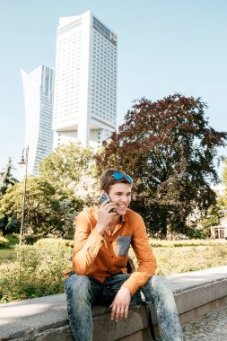 Şık giyinmiş genç adam Varşova sokaklarında. Kent merkezindeki adam. Avrupa şehir seyahat. Evrak çantalı adam. Kırmızı bir vida ile genç bir adam. Genç bir öğrenci eğitim için bir şeyin peşinde. Bir adam işe gider.