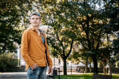 Şık giyinmiş genç adam Varşova sokaklarında. Kent merkezindeki adam. Avrupa şehir seyahat. Evrak çantalı adam. Kırmızı bir vida ile genç bir adam. Genç bir öğrenci eğitim için bir şeyin peşinde. Bir adam işe gider.