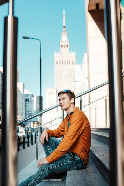 Şık giyinmiş genç adam Varşova sokaklarında. Kent merkezindeki adam. Avrupa şehir seyahat. Evrak çantalı adam. Kırmızı bir vida ile genç bir adam. Genç bir öğrenci eğitim için bir şeyin peşinde. Bir adam işe gider.