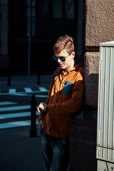 Şık giyinmiş genç adam Varşova sokaklarında. Kent merkezindeki adam. Avrupa şehir seyahat. Evrak çantalı adam. Kırmızı bir vida ile genç bir adam. Genç bir öğrenci eğitim için bir şeyin peşinde. Bir adam işe gider.