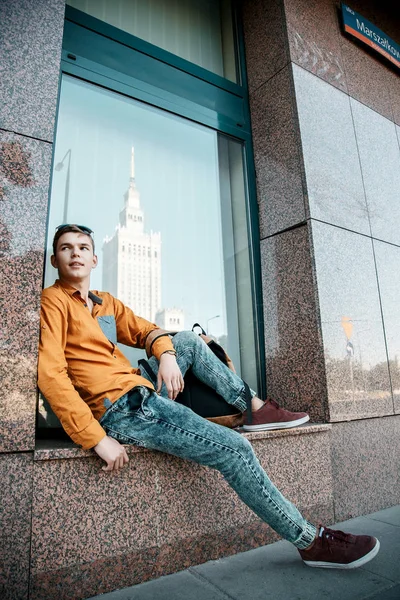 Şık giyinmiş genç adam Varşova sokaklarında. Kent merkezindeki adam. Avrupa şehir seyahat. Evrak çantalı adam. Kırmızı bir vida ile genç bir adam. Genç bir öğrenci eğitim için bir şeyin peşinde. Bir adam işe gider.